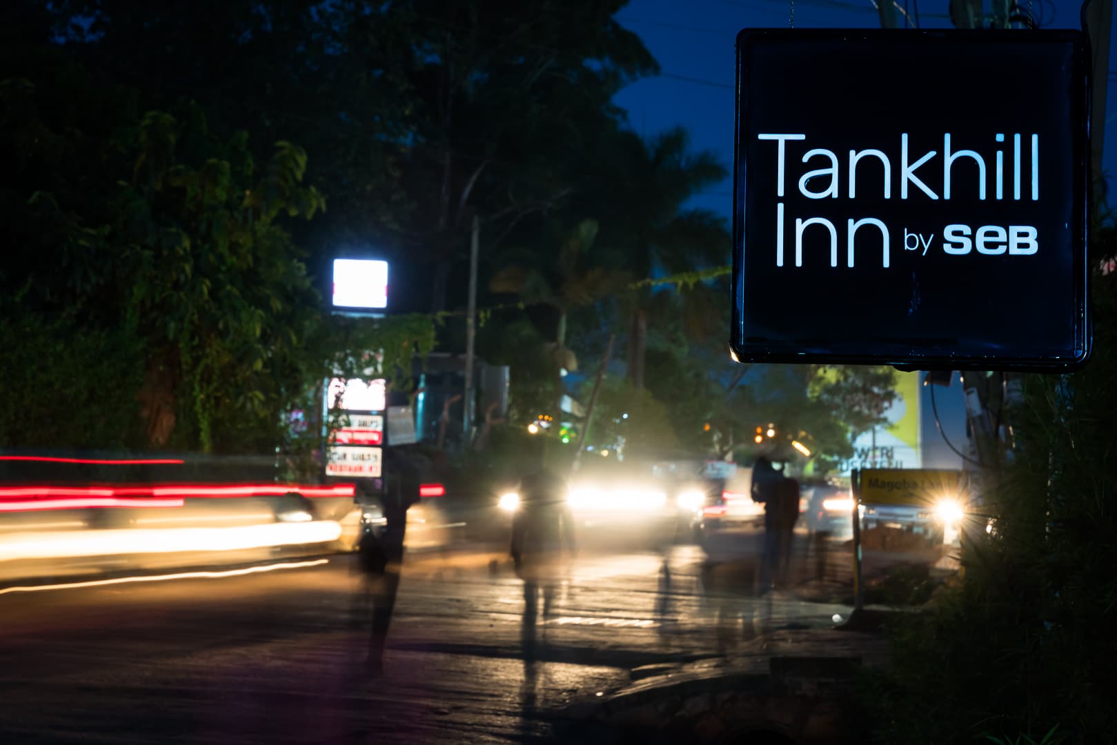 Tank Hill Inn street sign with night traffic light trails